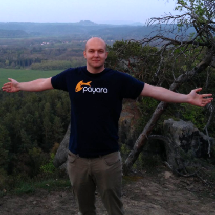 Pavel Pscheidl posing with his arms stretched in front countryside.